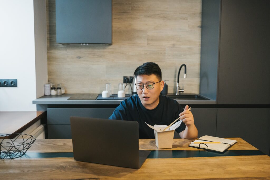 Man learning business intelligence topics while eating lunch at his computer.